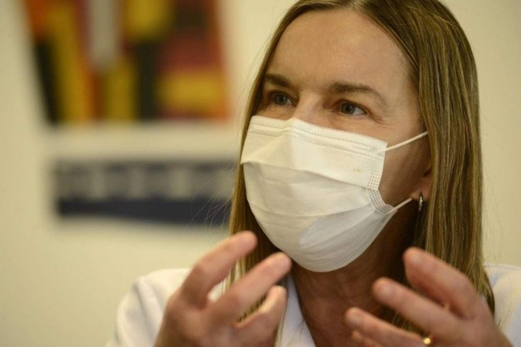 Neurocientista Lúcia Willadino Braga,usando máscara cirúrgica, explica estudo sobre Covid-19.