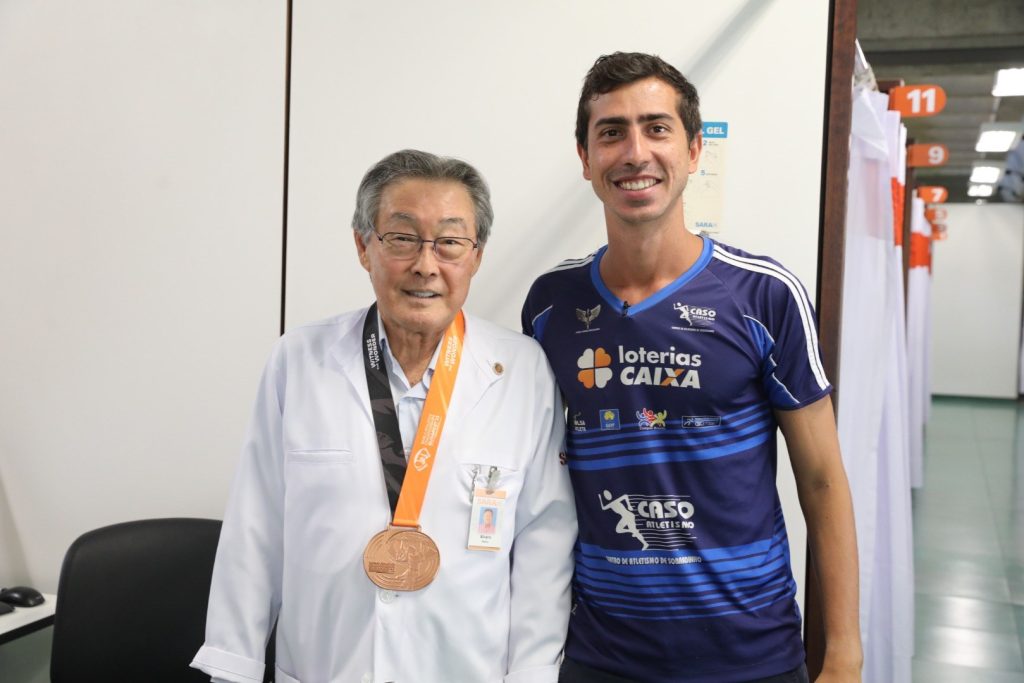 Caio Bonfim, em visita ao SARAH em 2023, homenageia Dr. Álvaro com a medalha de bronze que conquistou no Campeonato Mundial de Atletismo de 2023 em Budapeste.