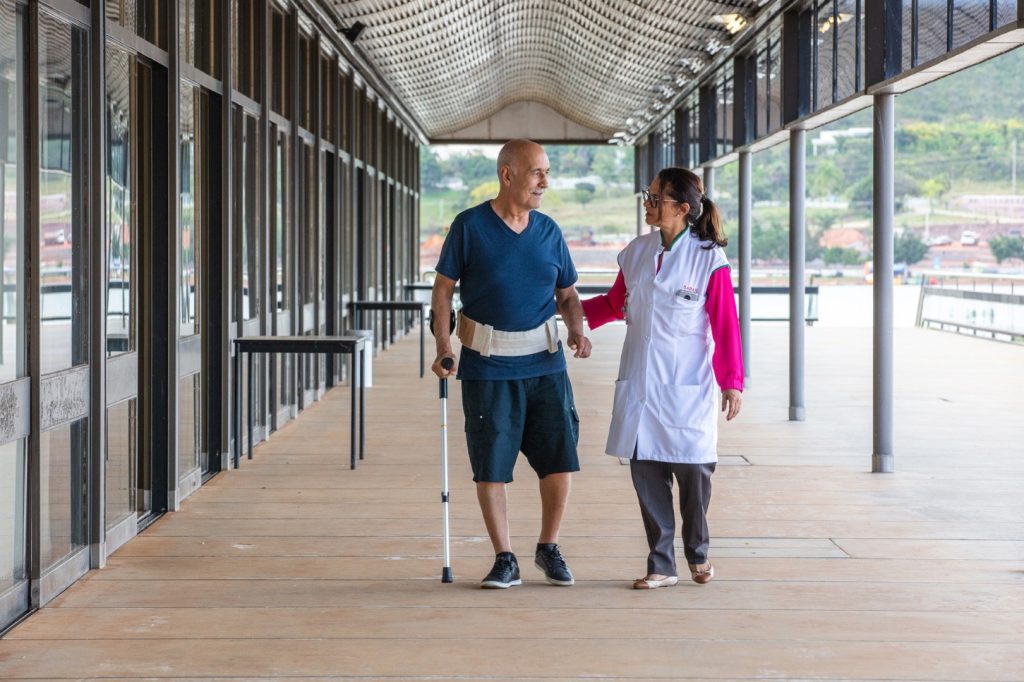 Paciente do SARAH sendo auxiliado por uma enfermeira da Rede em uma atividade de reabilitação no SARAH Lago Norte